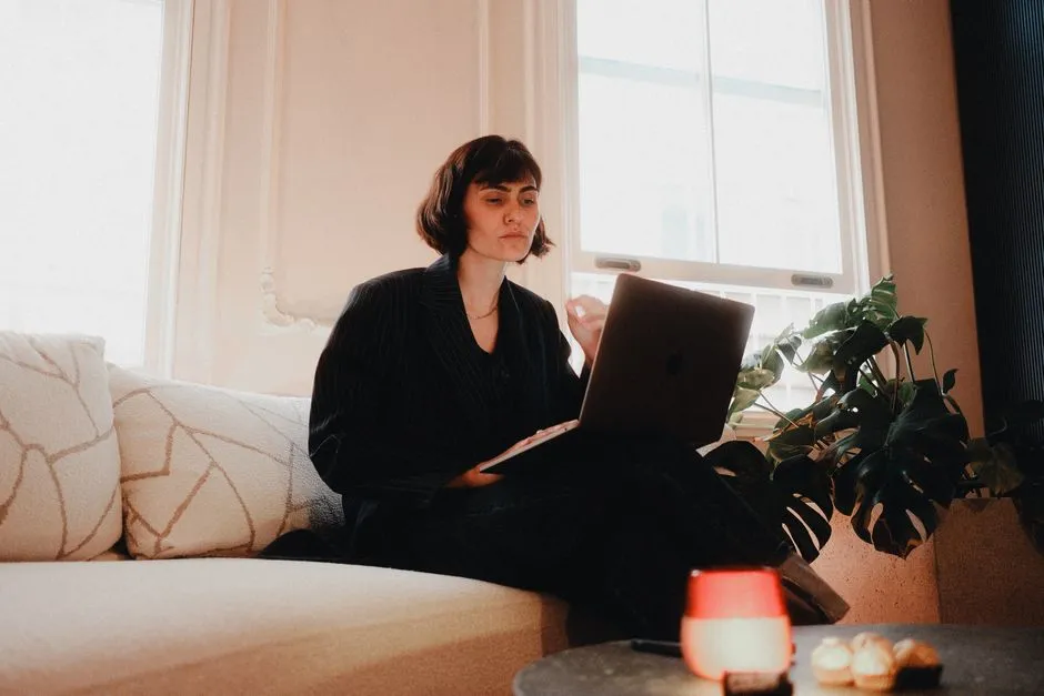 Person working on a laptop at a home desk, illustrative stock photo
